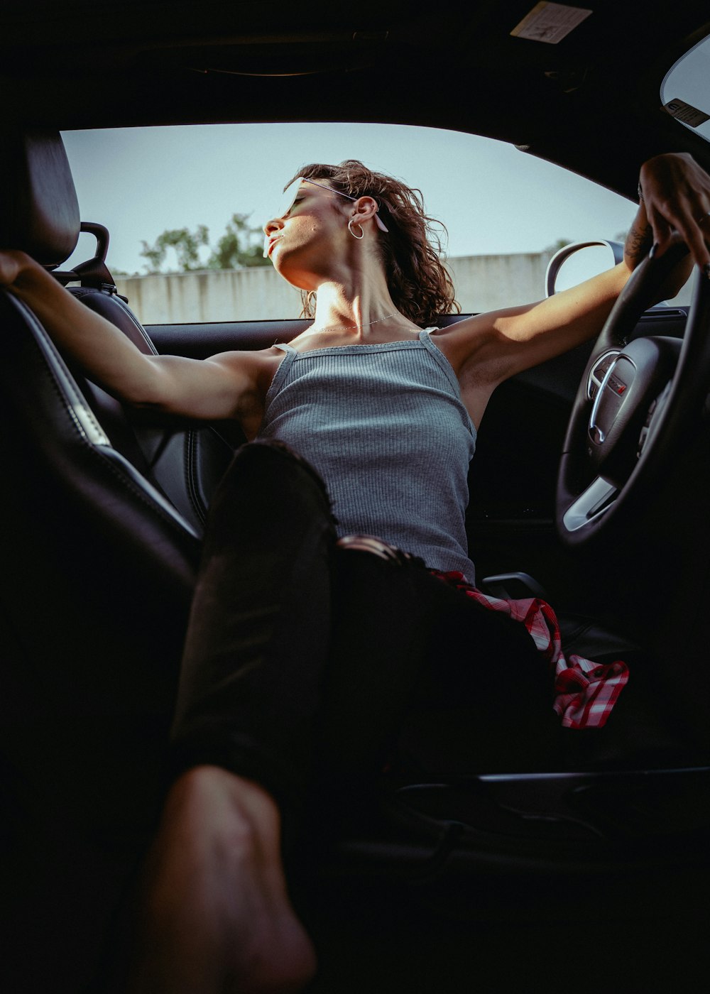 woman in gray tank top sitting on car seat