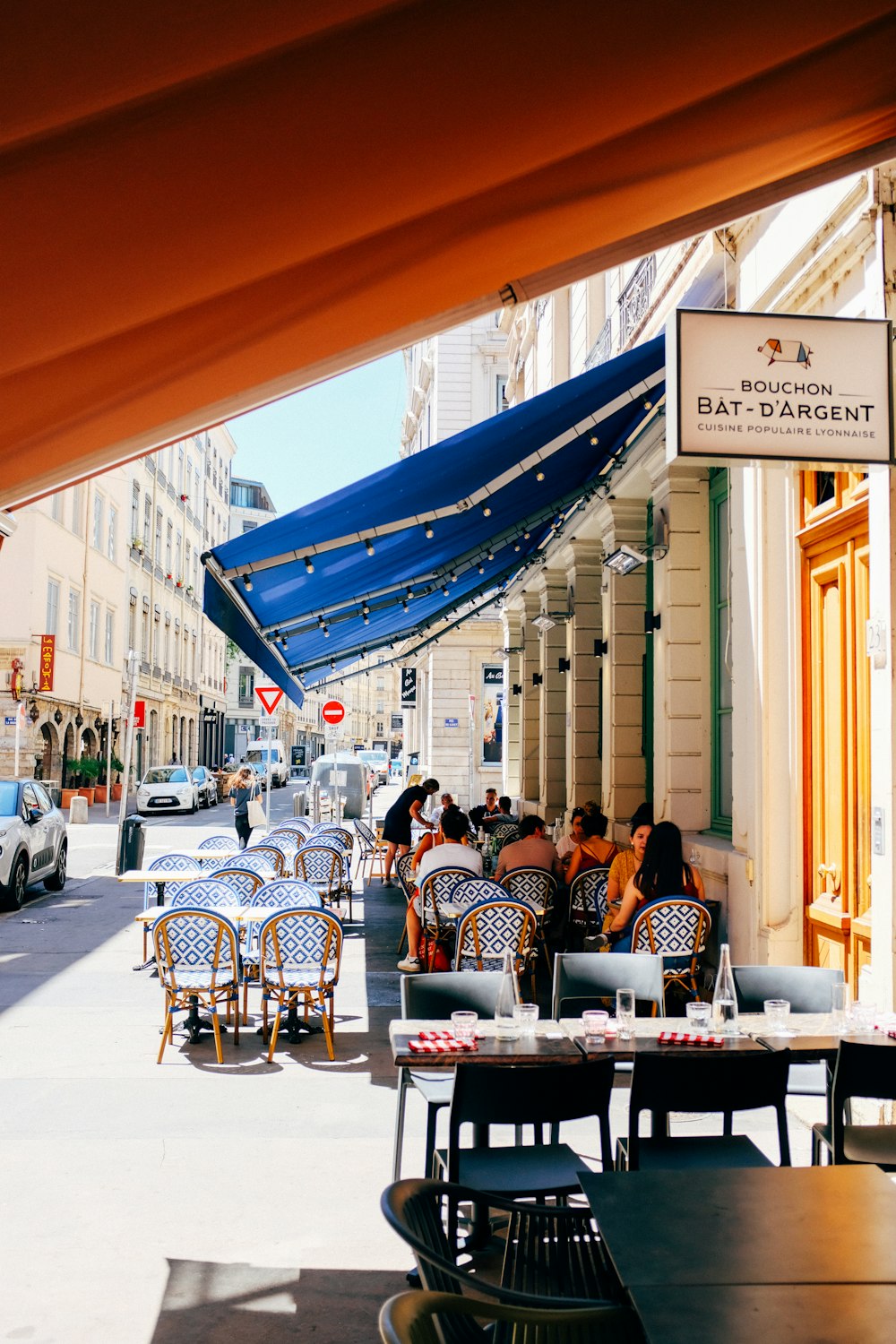 a group of people sitting at a table outside of a restaurant