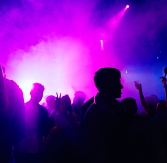 people standing on stage with purple lights