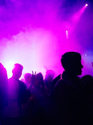 people standing on stage with purple lights