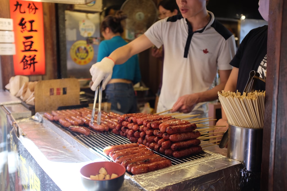 person in white apron holding brown wooden stick