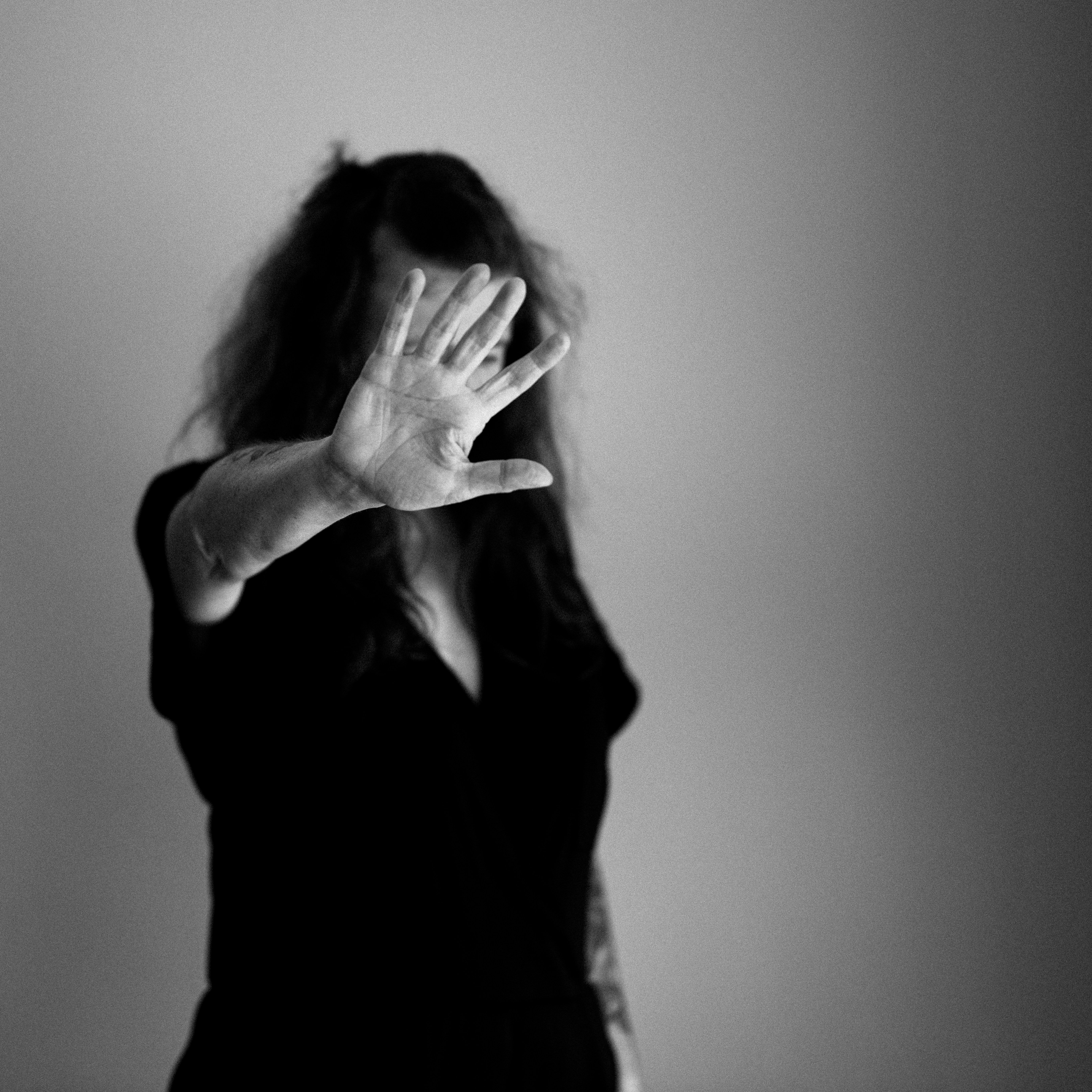 donna che si copre il viso con la mano