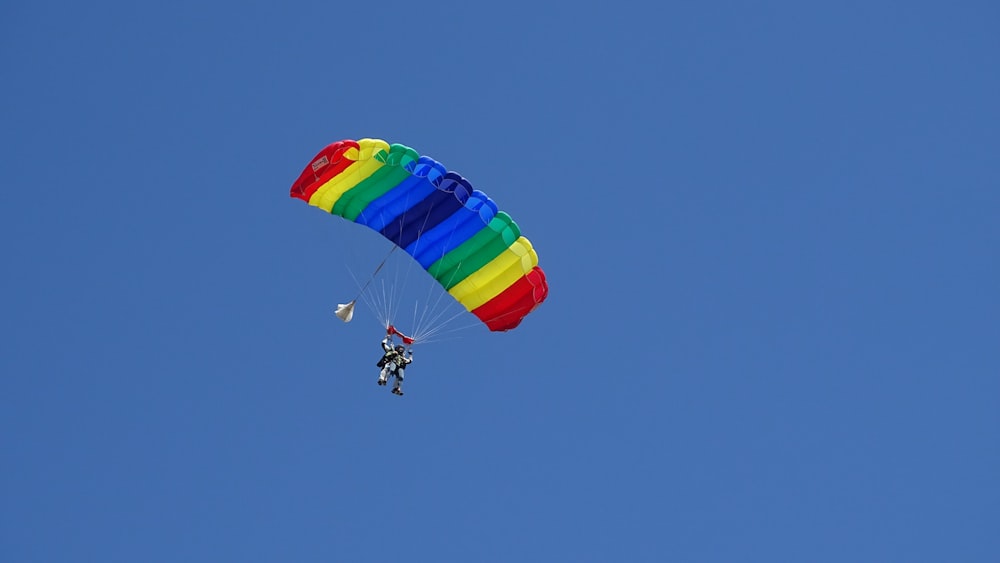 person riding on red yellow and blue parachute