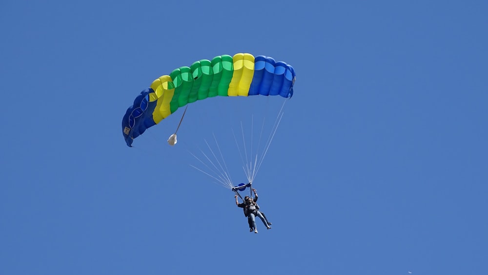 Persona en paracaídas amarillo y azul