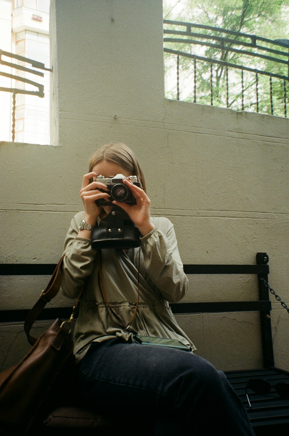 man in brown jacket taking photo using black dslr camera