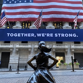 woman in black dress statue near american flag during daytime