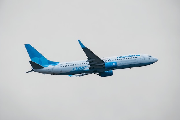 blue and white airplane in mid air