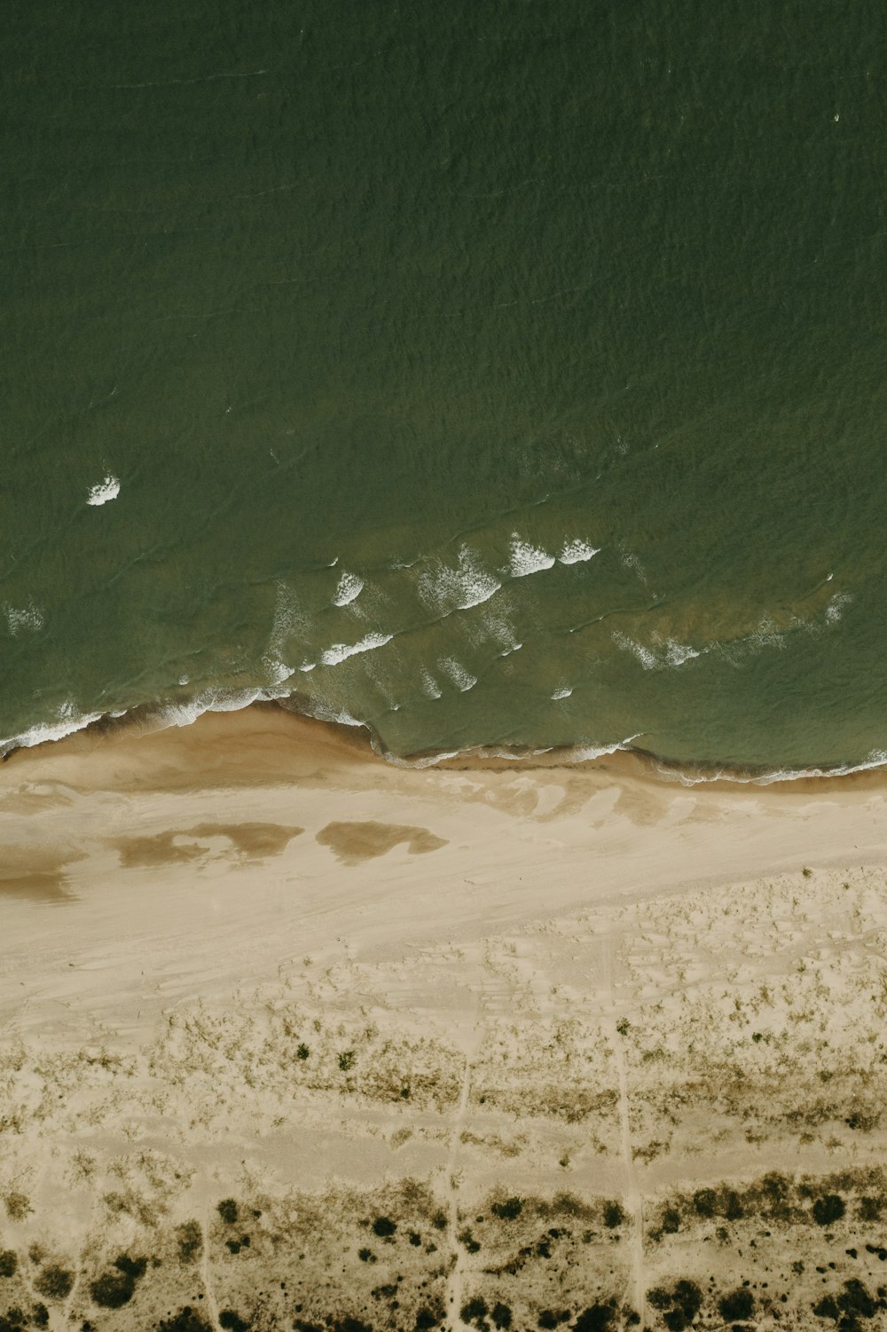 aerial view of sea waves crashing on shore during daytime