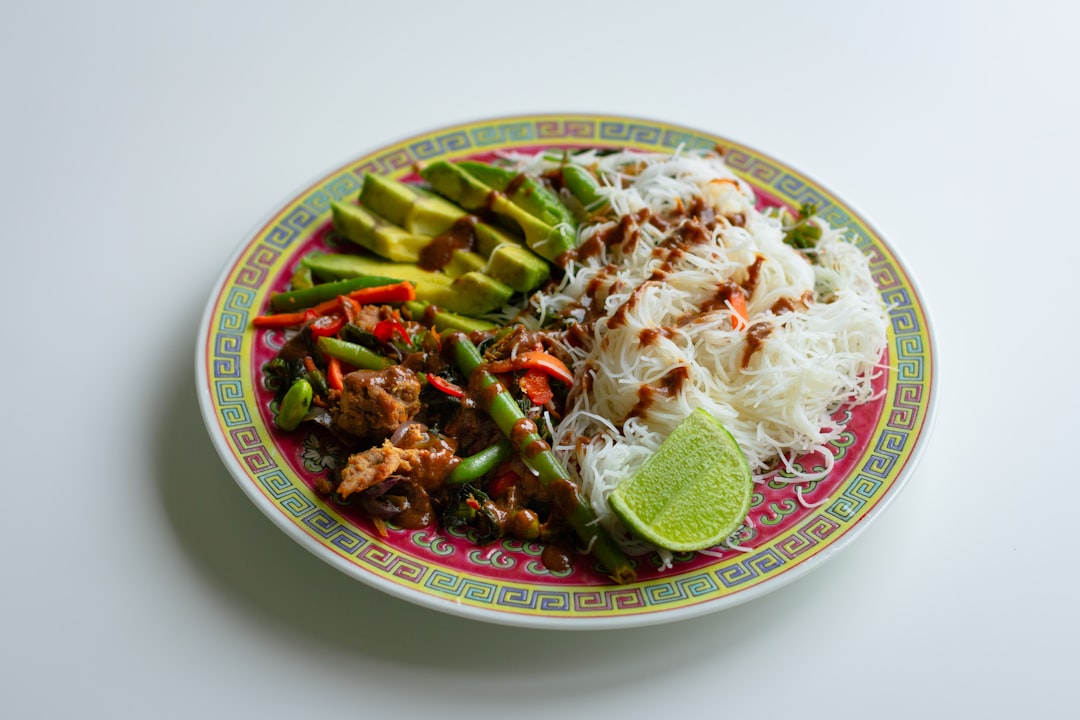 white and red ceramic bowl with food, Vegan stir fry with rice vermicelli