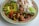 A vibrant plate of vegan Peruvian food garnished with fresh herbs.