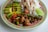 A vibrant plate of vegan Peruvian food garnished with fresh herbs.