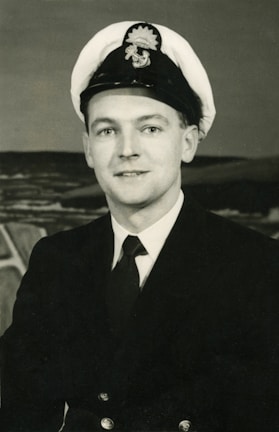 Portrait of a confident ship captain in uniform against a harbor backdrop.