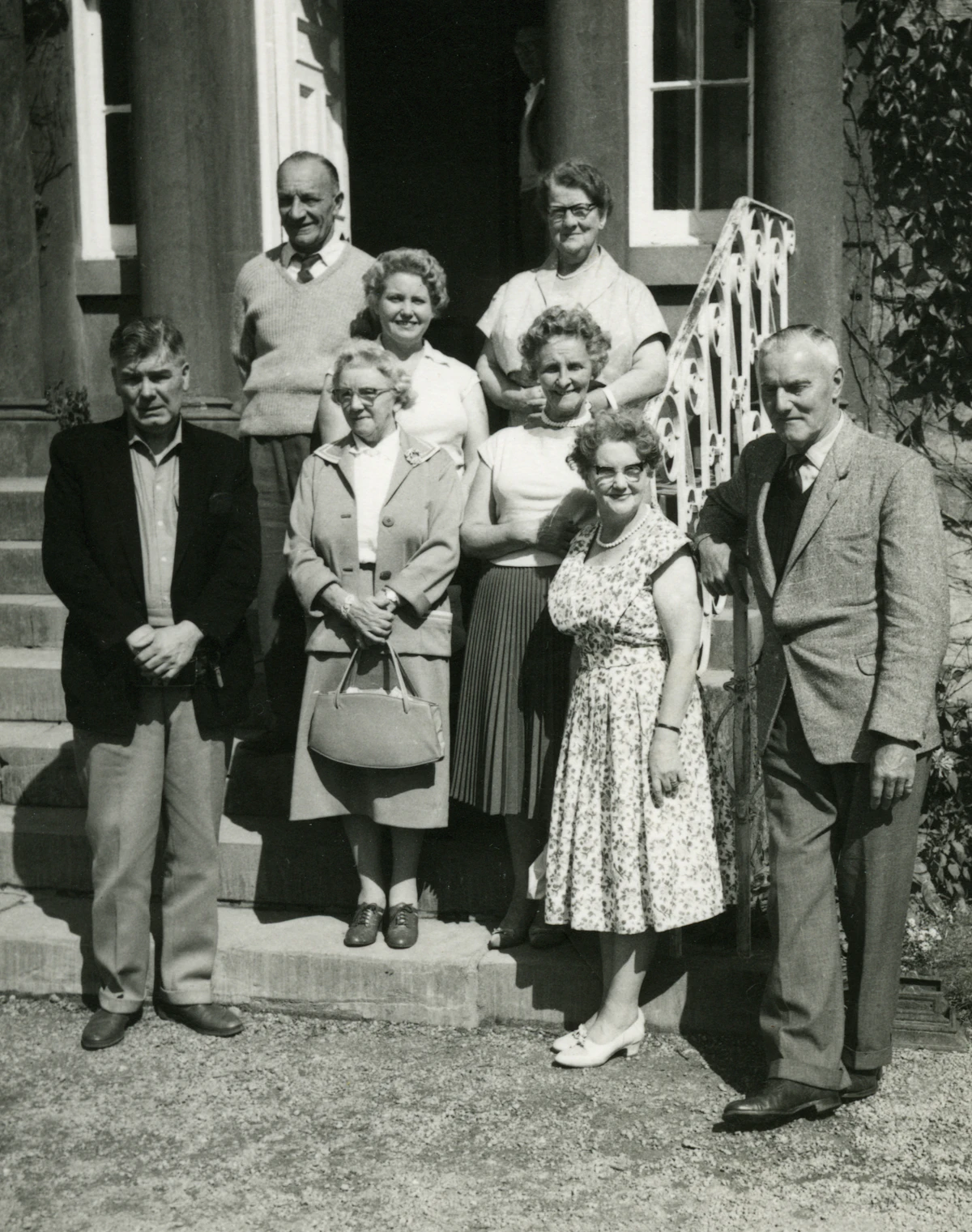 Grayscale photo of family standing on grass field