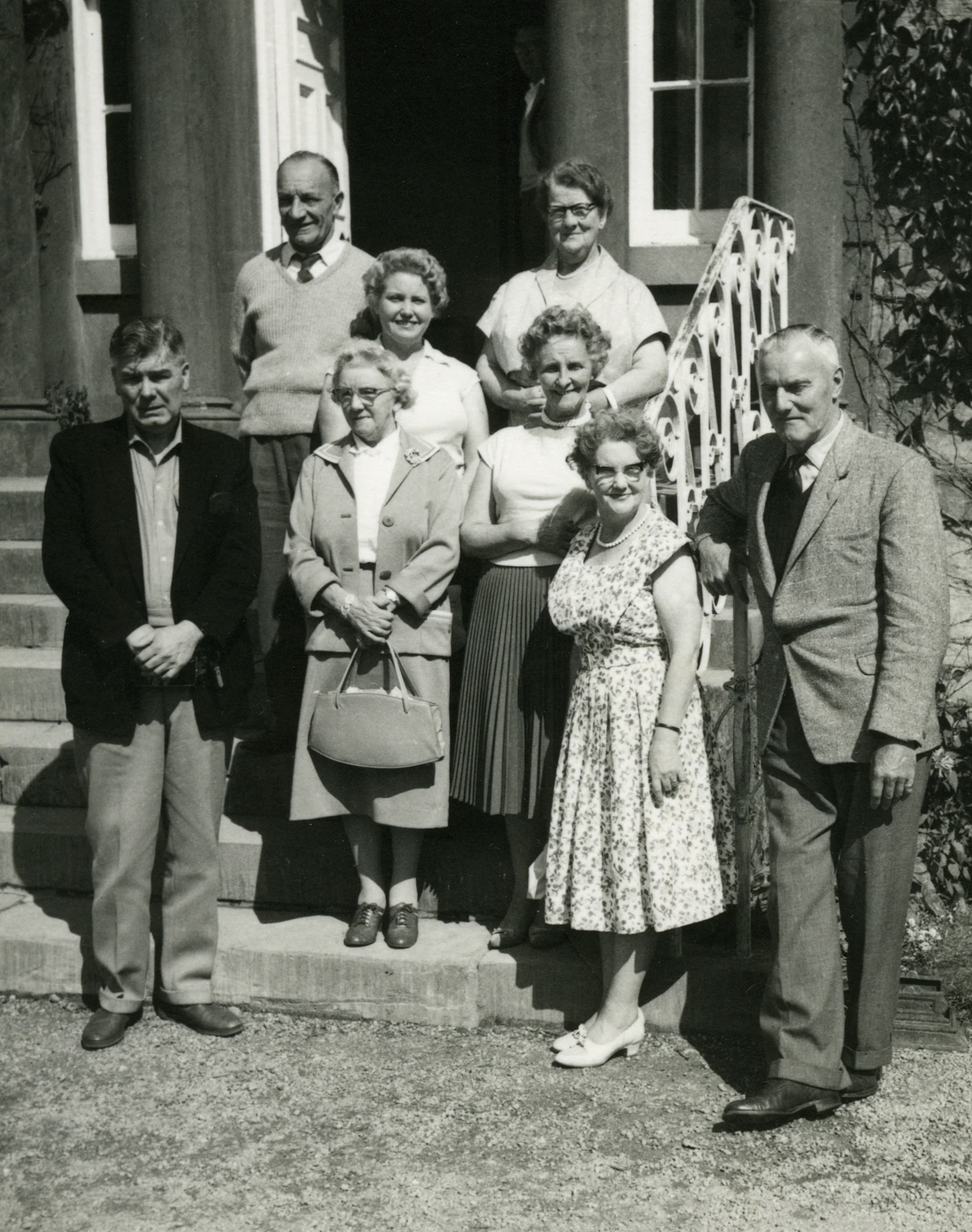 Grayscale photo of family standing on grass field