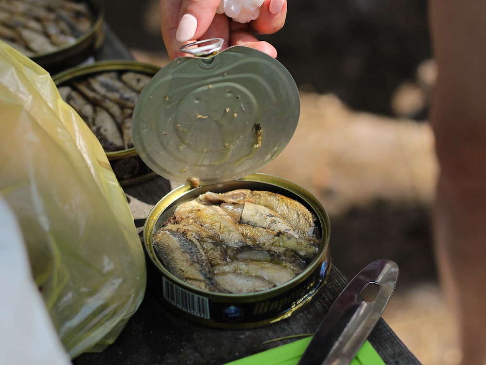 persona sosteniendo un frasco de vidrio transparente con polvo amarillo