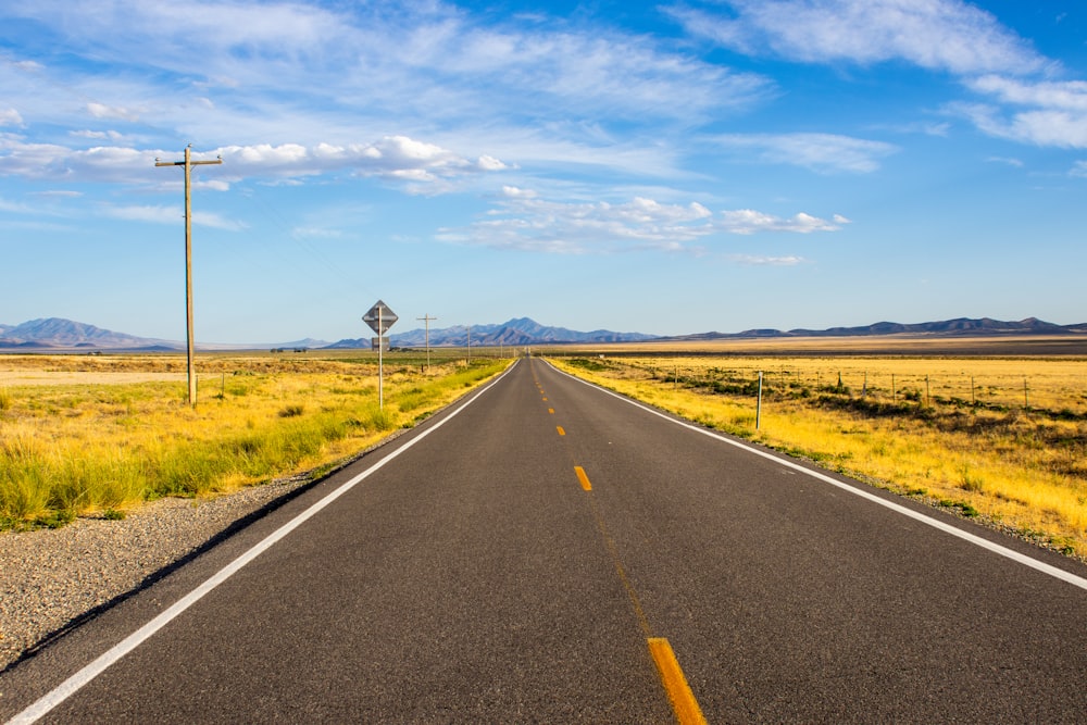 gray asphalt road under blue sky during daytime