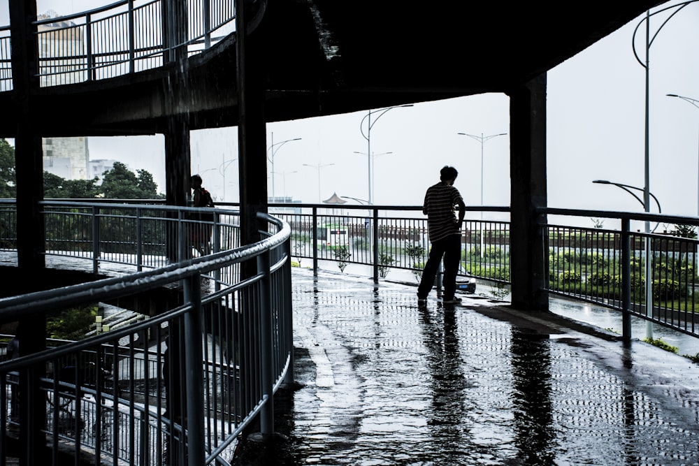 man and woman standing on bridge during daytime