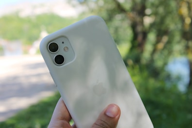 A person using a smartphone outdoors in natural light.