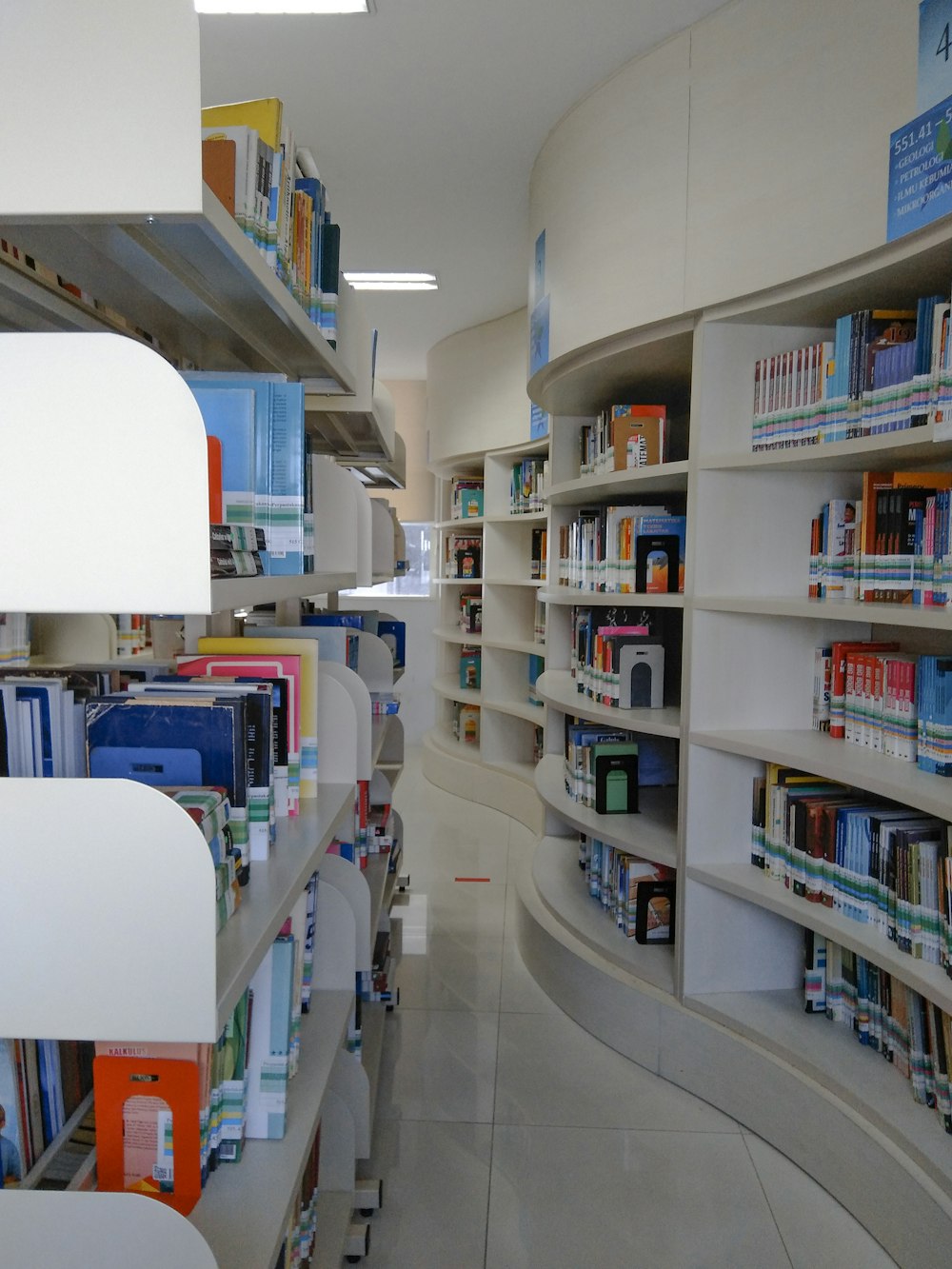 white wooden book shelves in library