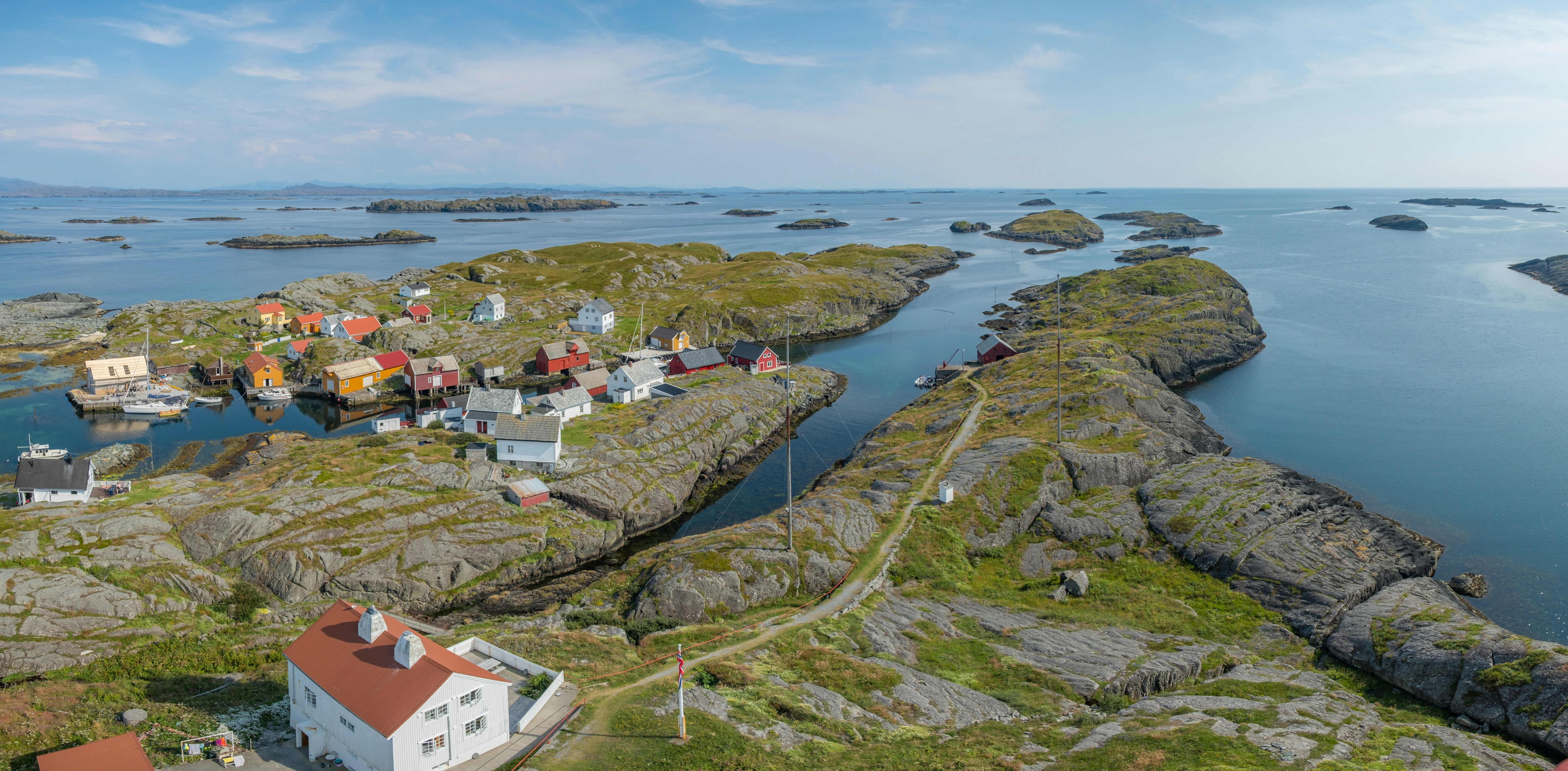 houses on green grass field near river during daytime