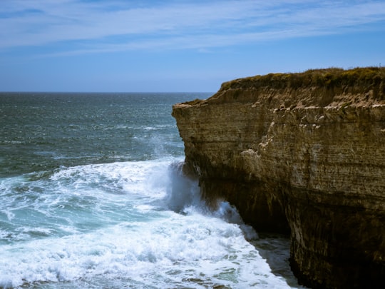 brown rock formation beside sea during daytime in Santa Cruz United States
