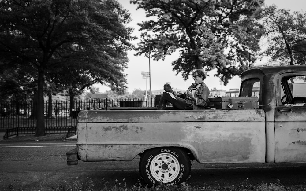 man and woman sitting on white car