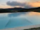 A serene infinity pool overlooking lush jungle hills at sunset.