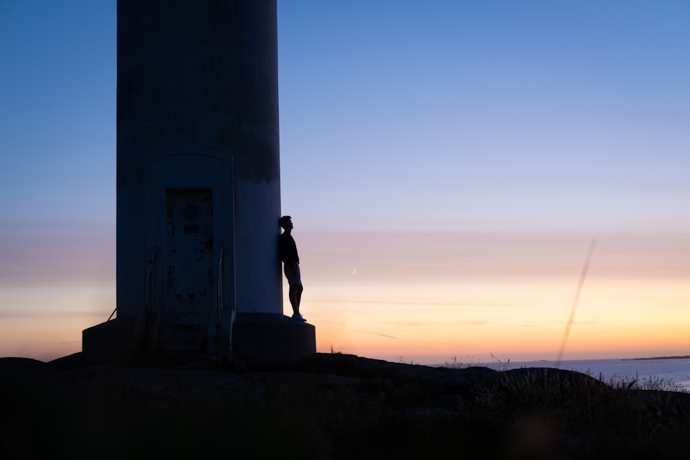 silhouette of man standing on top of building during sunset