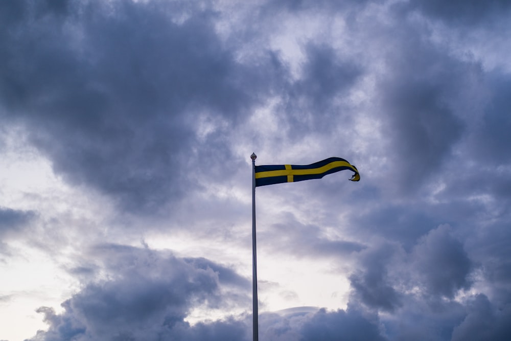 yellow flag on pole under cloudy sky
