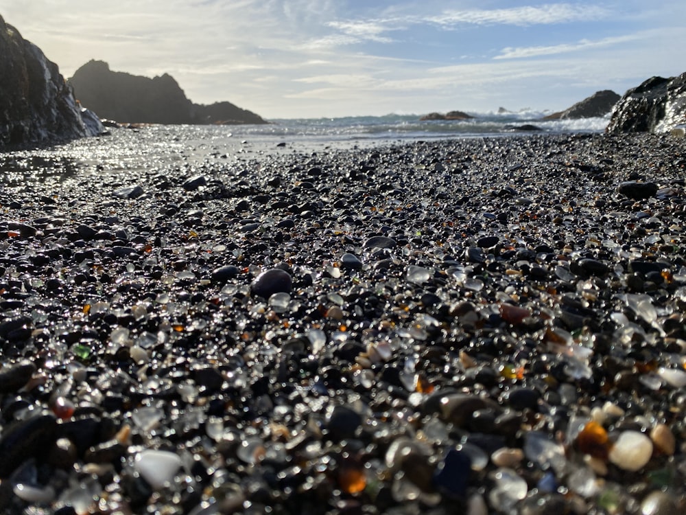 pierres noires et blanches sur le bord de la mer pendant la journée