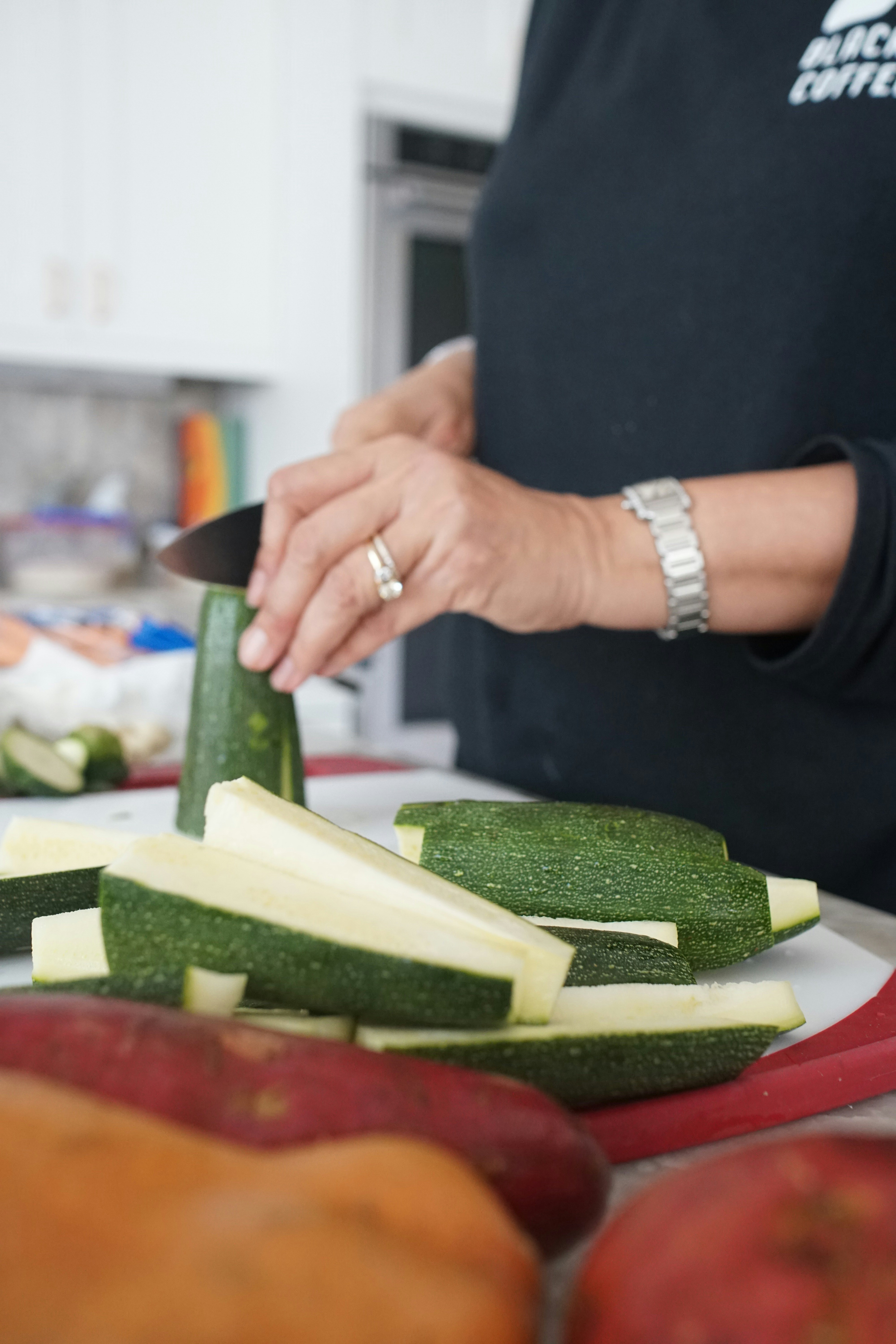 person holding sliced cucumber on brown wooden chopping board, avocado salsa