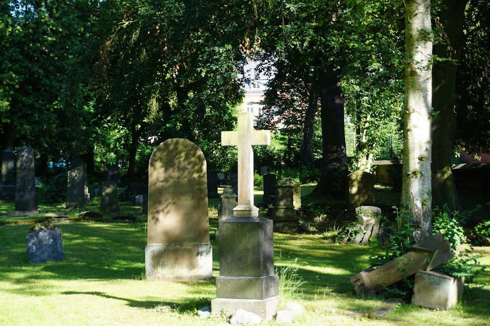 gray cross statue on green grass field