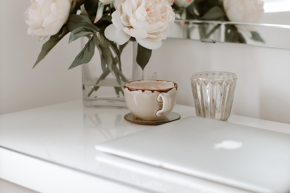 white flower on brown ceramic cup on white table