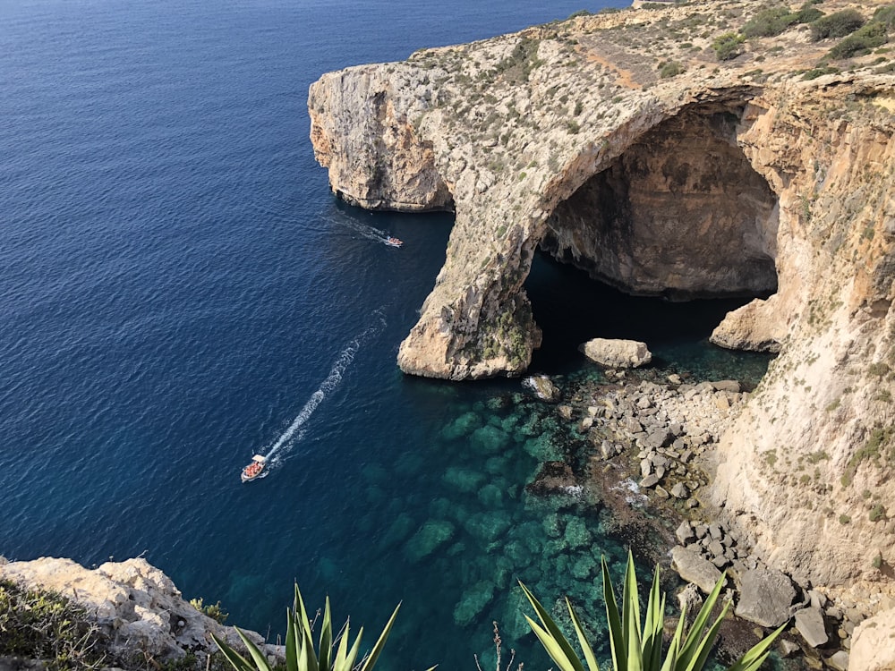 brown rock formation on body of water during daytime