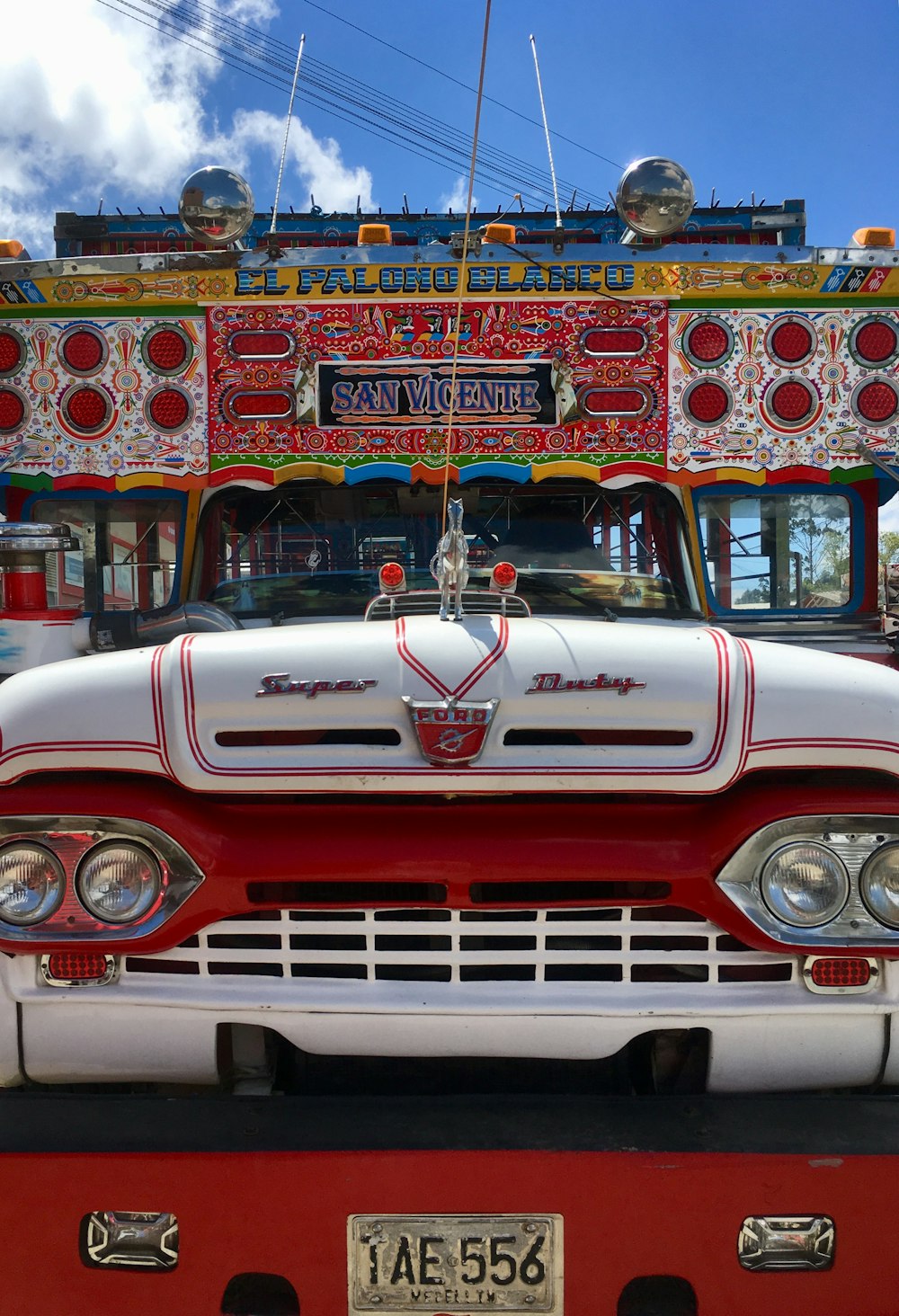 red and white chevrolet car in front of store