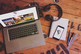 macbook pro beside black headphones and black headphones