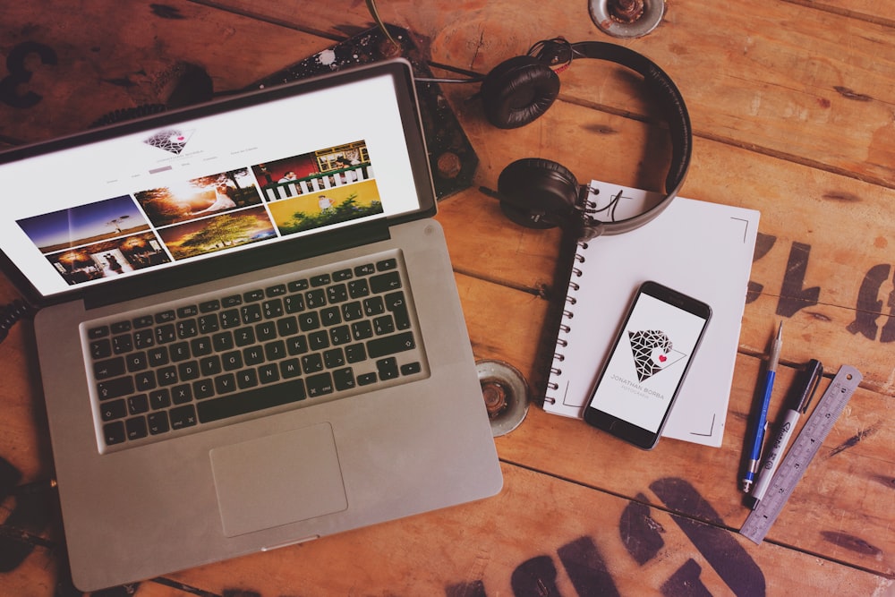 macbook pro beside black headphones and black headphones