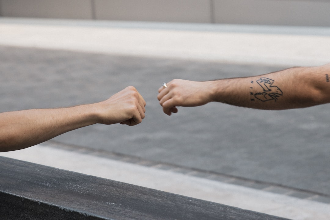 person with black and red tattoo on right hand