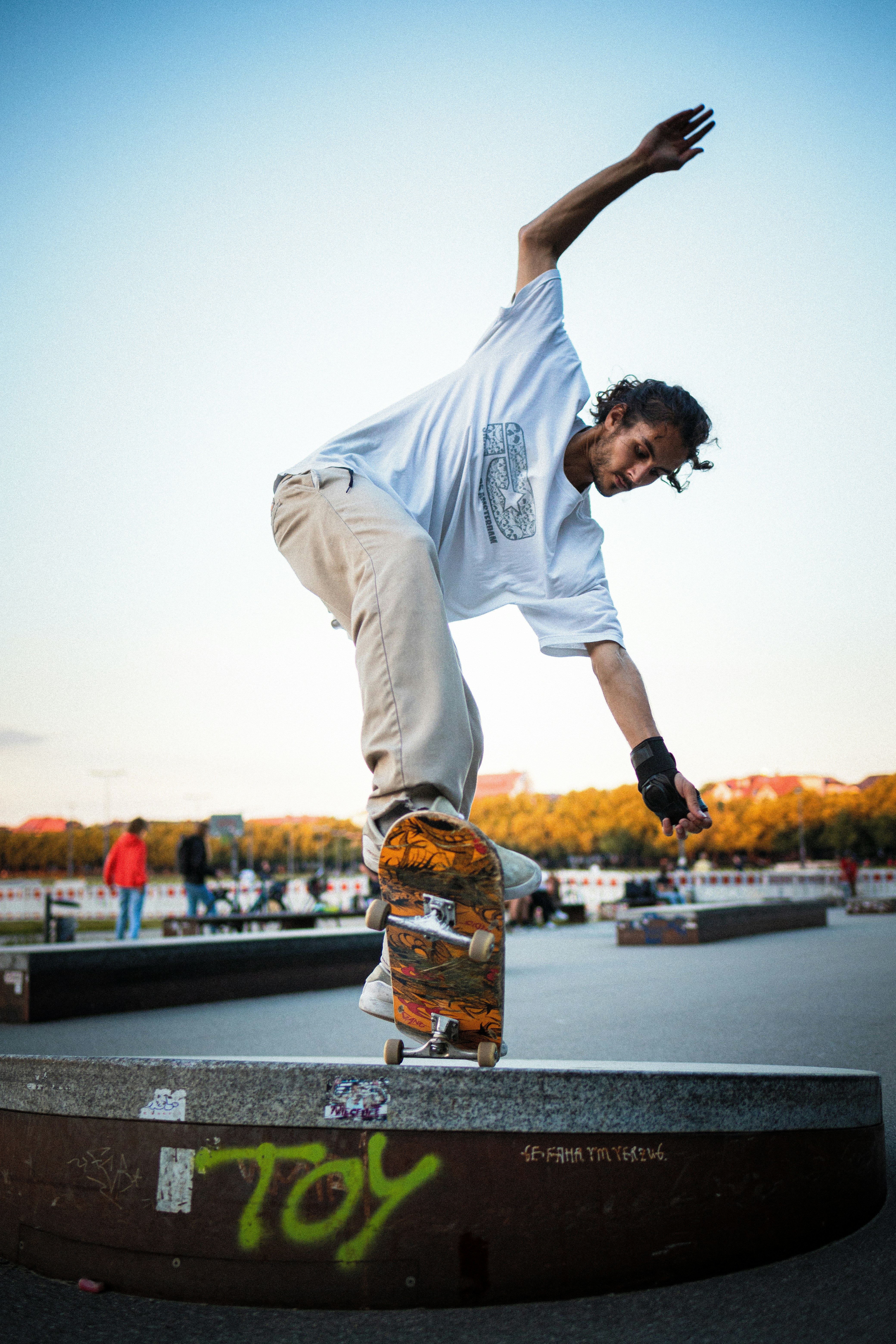 man in white crew neck t-shirt and yellow shorts jumping on black asphalt road during