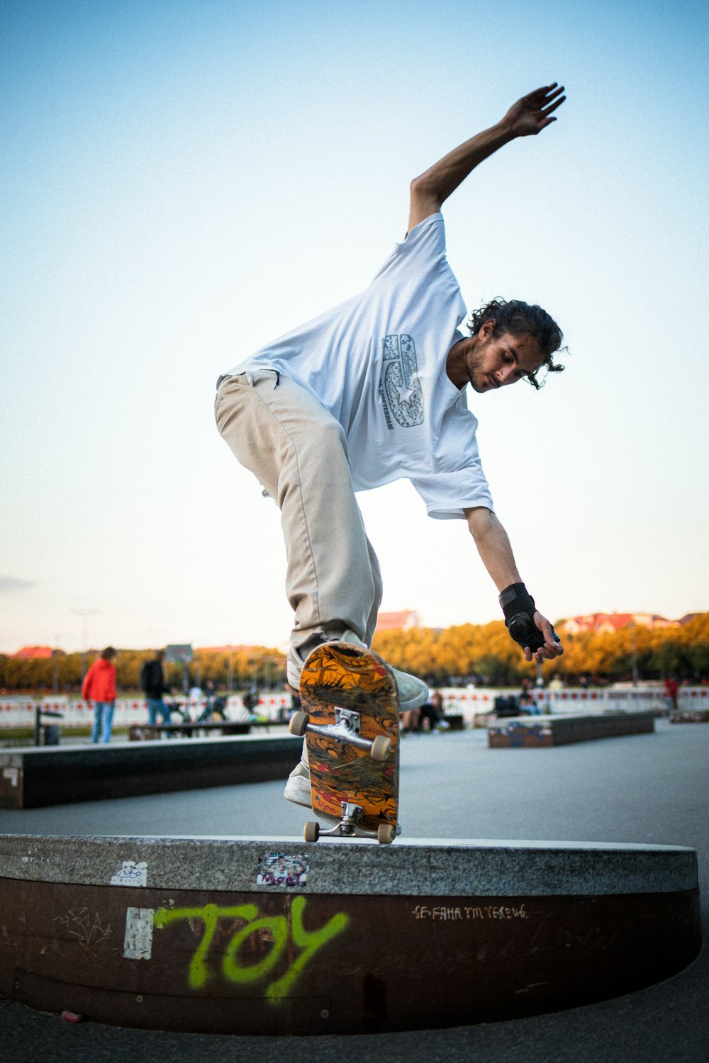 man in white crew neck t-shirt and yellow shorts jumping on black asphalt road during