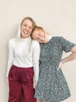 girl in white crew neck t-shirt beside girl in black and white floral dress
