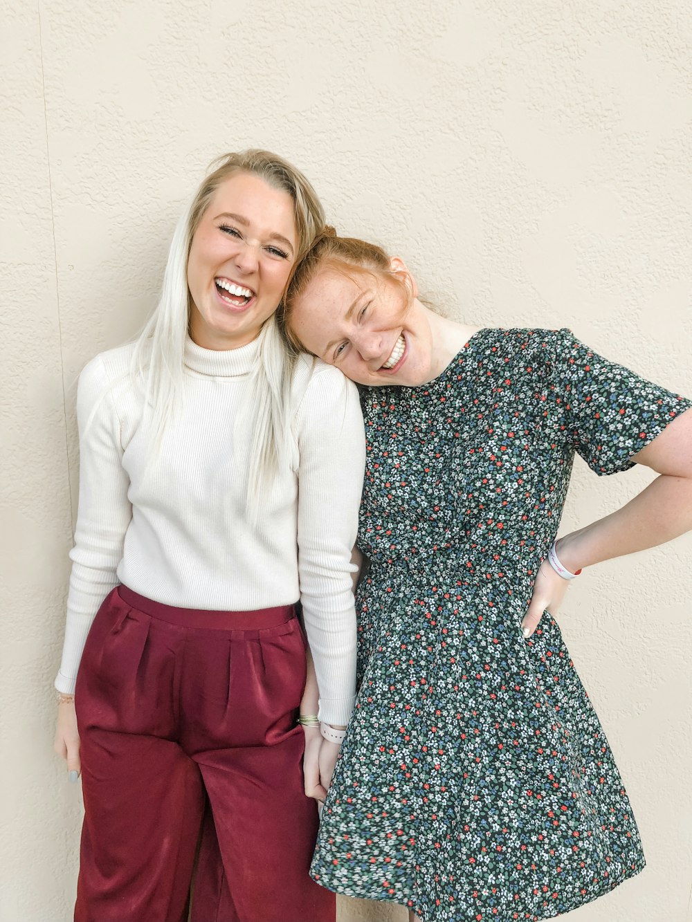 girl in white crew neck t-shirt beside girl in black and white floral dress