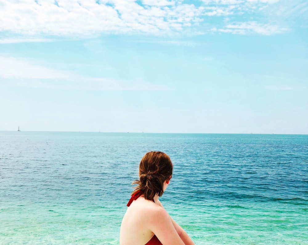 woman in black bikini top standing on beach during daytime