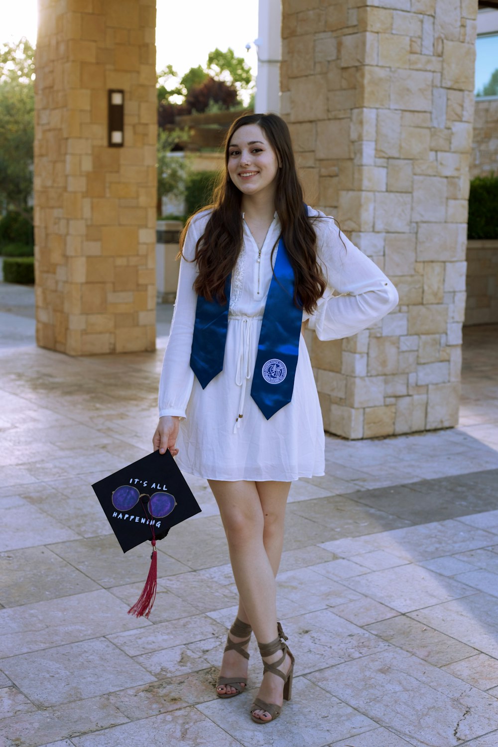 woman in white coat holding black and red handbag