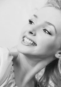 Close-up of a joyful Black woman with natural hair and colorful attire.