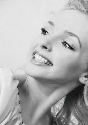 A joyful Black woman wearing a beautifully styled braid, smiling confidently in natural light.