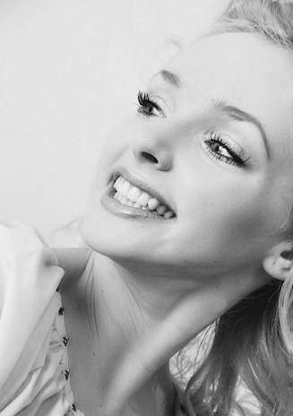 A joyful woman smiling brightly, symbolizing resilience and hope after overcoming challenges.