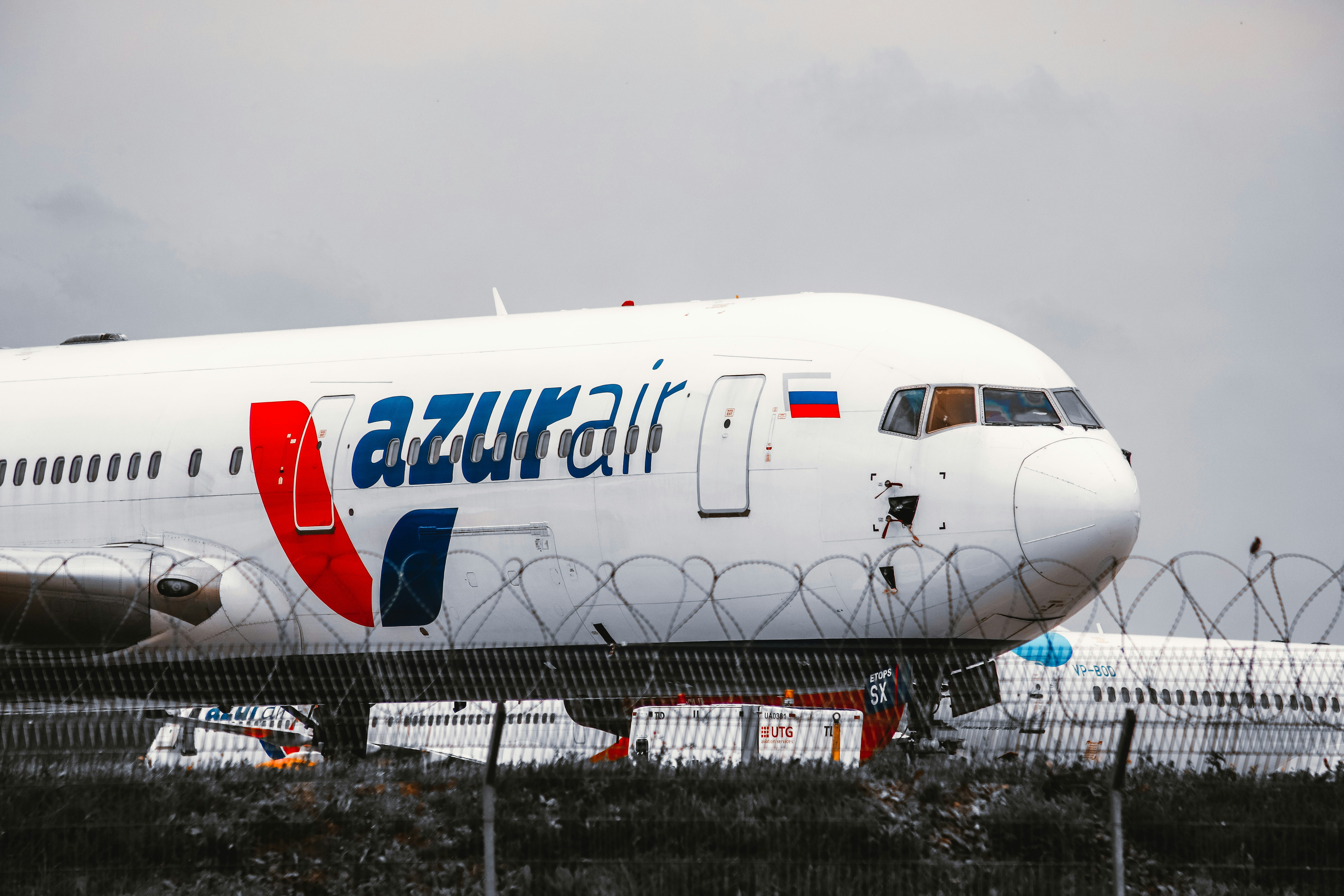 white and blue airplane on black and gray ground, 