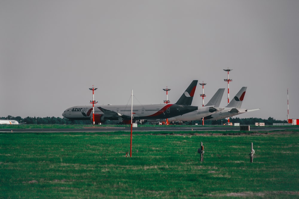 white and red airplane on green grass field during daytime