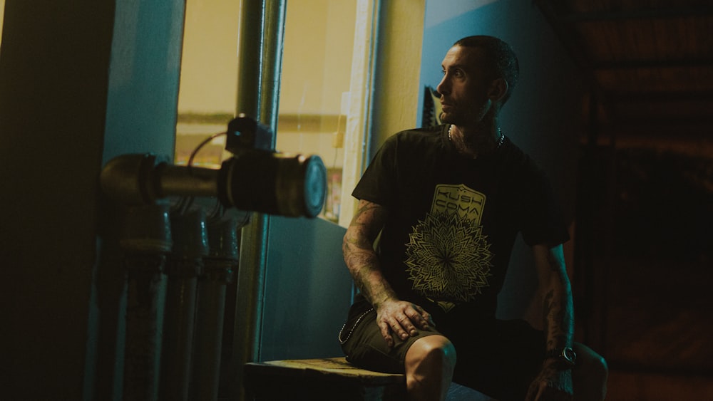 man in black crew neck t-shirt sitting on chair